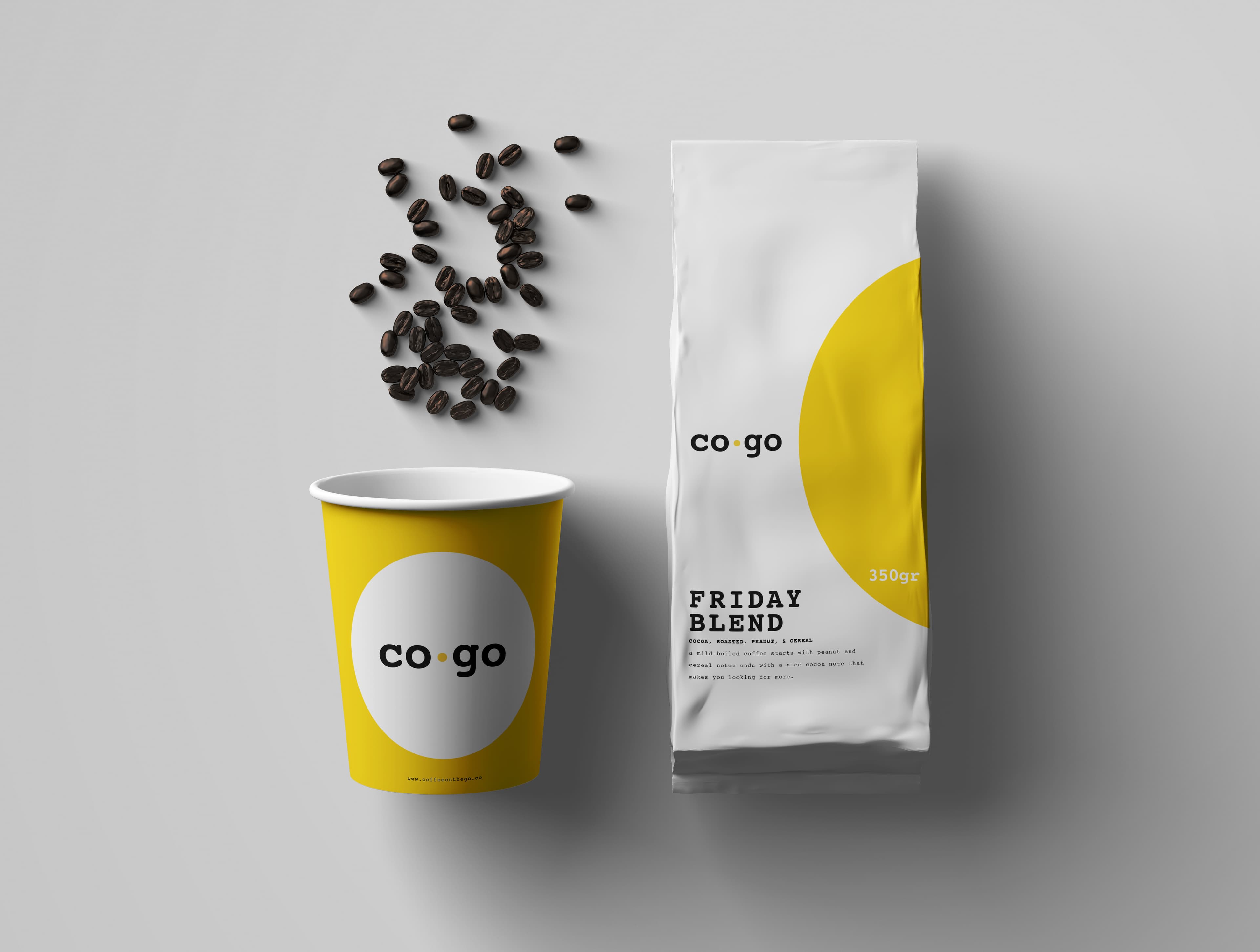 A yellow CoGo paper cup seen from above, coffee beans scattered beside it